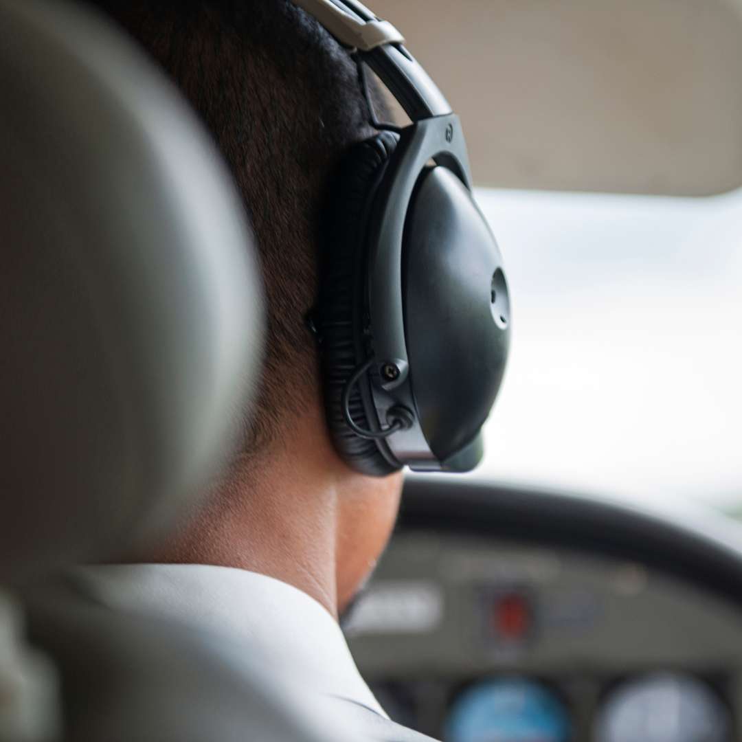 back of pilot head with headset in cockpit