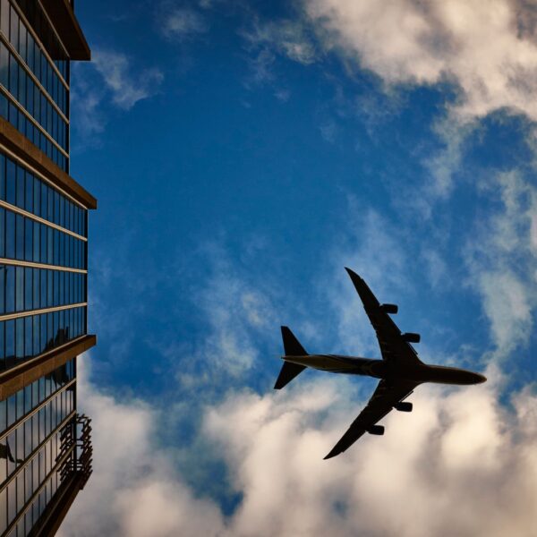 airplane flying by a building