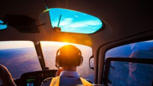 Pilot flies plane at sunset
