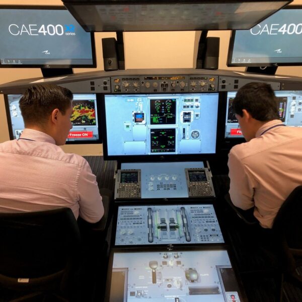 Two pilots sit in airplane simulator