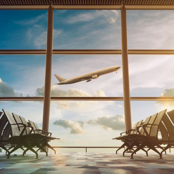 Airplane takes off between window panes in empty airport gate