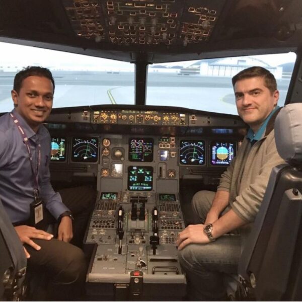 Two pilots in training smile in cockpit