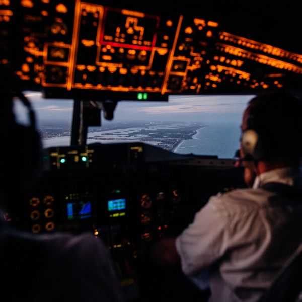 two pilots in cockpit mid-flight